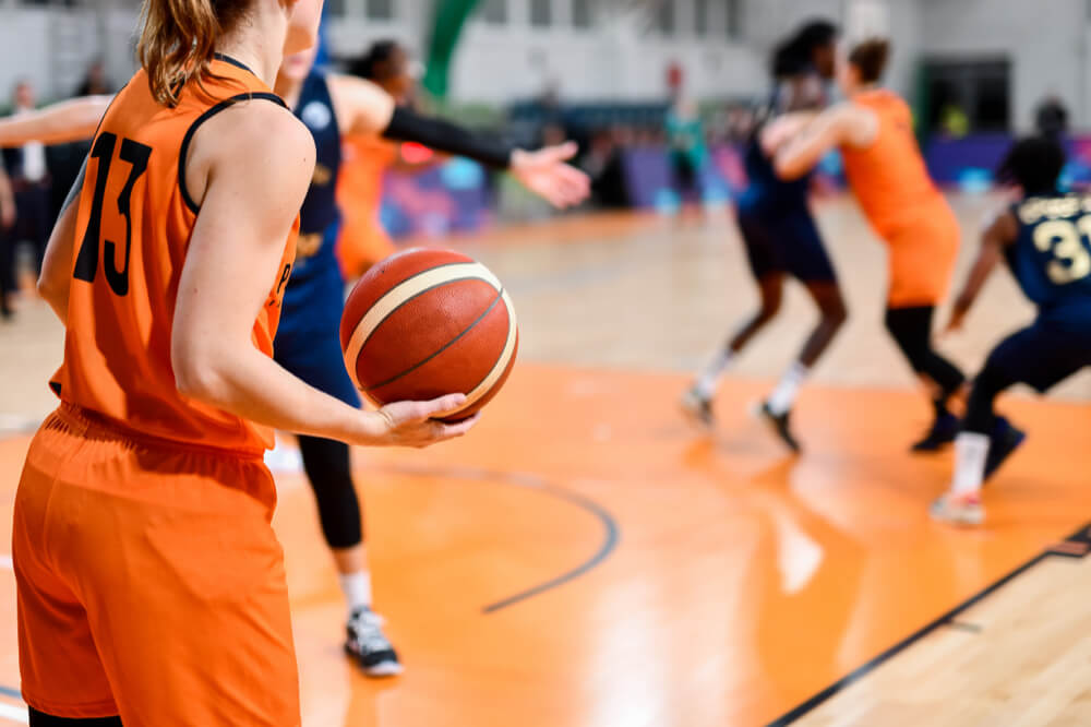 試合中にボールを持つ女子バスケットボール選手