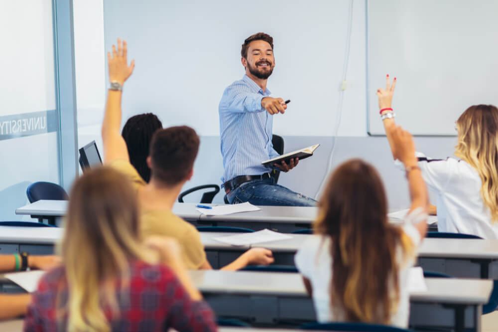 授業で手を挙げる学生たちと先生