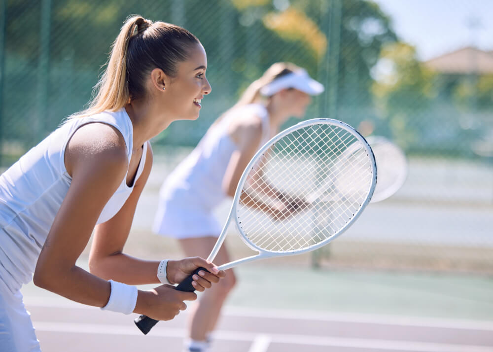 ダブルスで構える女子テニス選手