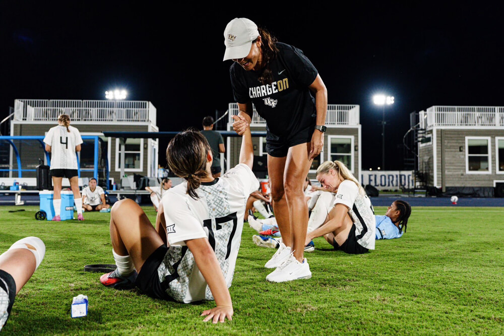 試合後に選手の手を取って起こすUCF女子サッカー部のコーチ