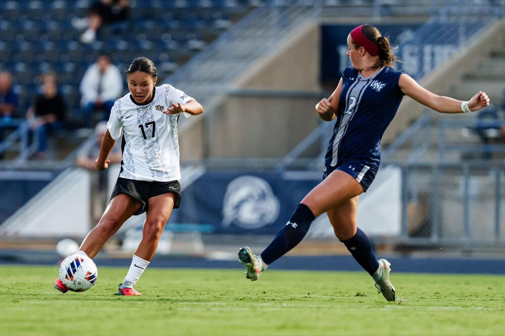 試合でボールを蹴るUCF女子サッカー部の選手