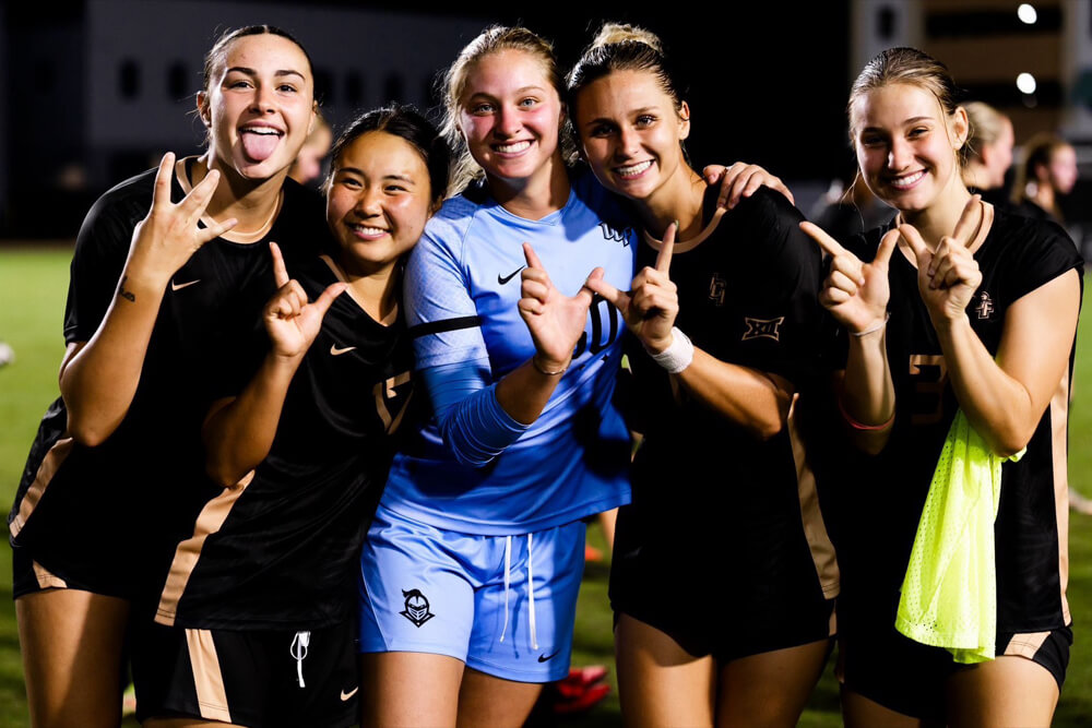 ハンドサインで写真に応えるUCF女子サッカー部の選手たち